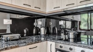 A compact kitchen with a built-in oven, a stovetop, and a coffee maker.