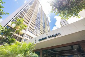 A modern building with a sign reading 'Wai Kik Banyan'. - Waikiki Banyan Corner Unit w/ In-Unit W/D & Parking (Honolulu)