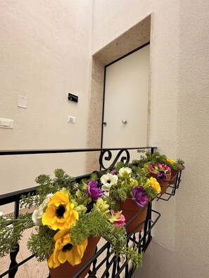 A staircase with a handrail and flower planters on the side. - "La Brogna" Apartment - Downtown Mazara del Vallo (Mazara del Vallo)