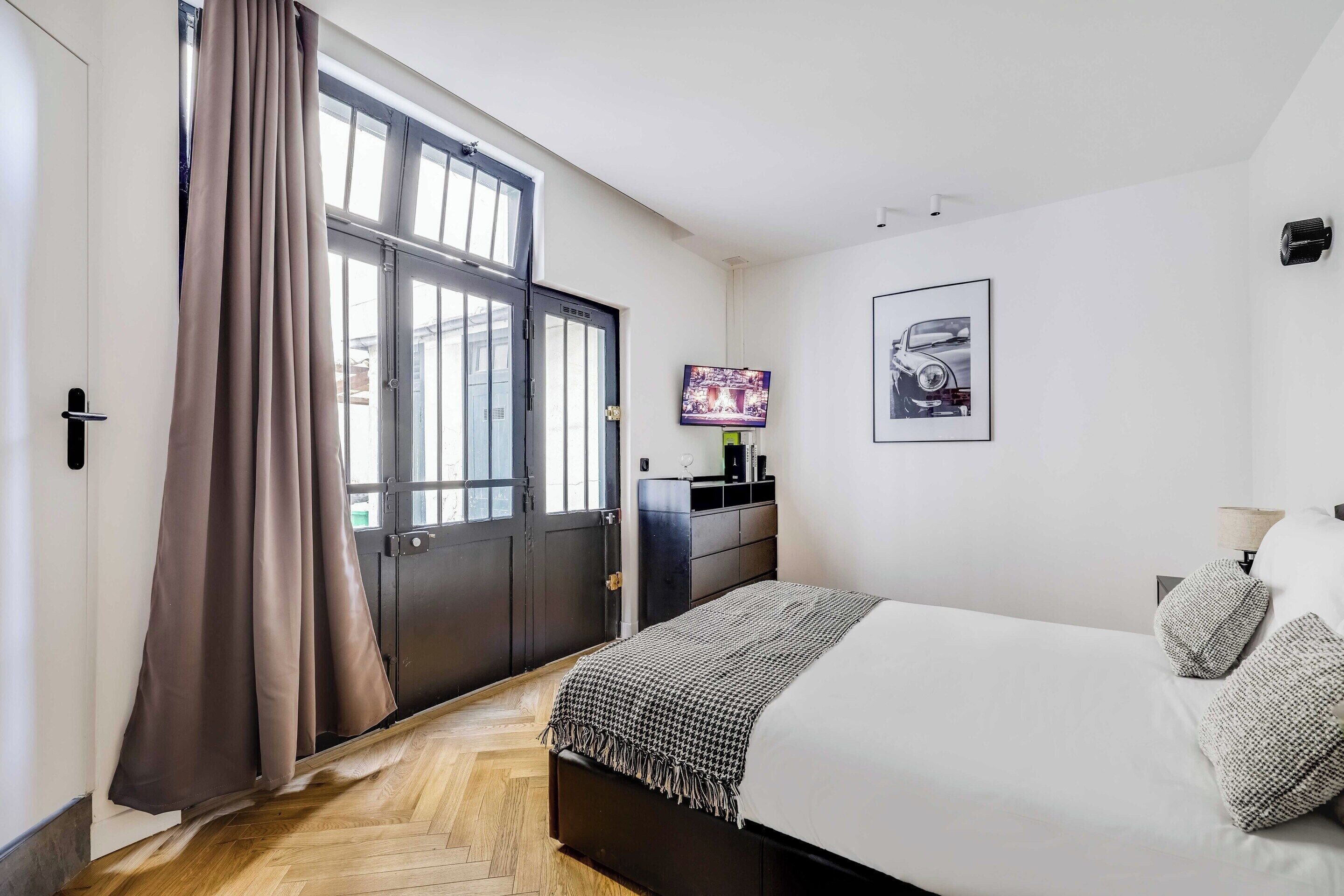 Una camera da letto con un letto, una televisione e un quadro appeso al muro.