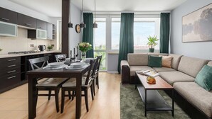 A modern apartment with a dining area, kitchen, and living room. - Wola Flat Near City Center (Warsaw)