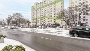 A multi-story residential building with a parking lot in front. - Wola Flat Near City Center (Warsaw)