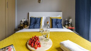 A hotel room with a bed, a bedside table with a lamp, a nightstand, and a wall-mounted light fixture. - Quiet Flat With Garage (Warsaw)