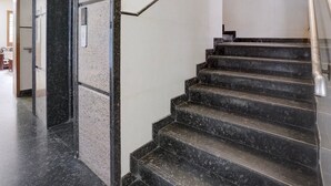 Un escalier avec une rampe et une porte portant une plaque avec un numéro.