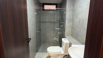 Ein Badezimmer mit Toilette, Waschbecken und Duschkabine.