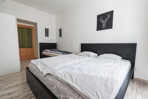 Ein Schlafzimmer mit einem Bett, einem Kleiderschrank, einer Tür und einem Wandbild.