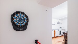 Eine Dartscheibe an einer Wand, im Hintergrund ist eine Küche zu sehen.