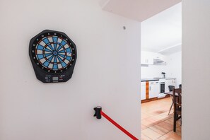 Eine Dartscheibe an einer Wand, im Hintergrund ist eine Küche zu sehen.