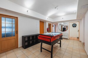 A room with a foosball table, a mirror, and a dartboard. - Prague Group Stay for 20 • Billiard•Foosball•Darts (Praha)