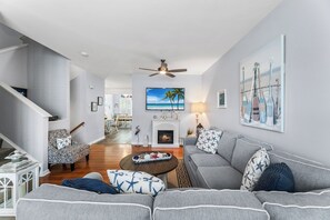 Ein modernes Wohnzimmer mit Kamin, einer Sofagarnitur, einem Couchtisch und einem Fernseher.