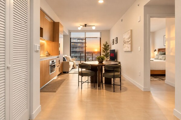 Un appartement moderne comprenant une cuisine, un coin repas et une chambre.