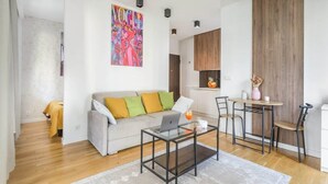 Ein modernes Wohnzimmer mit einer Couch, einem Couchtisch und einem Gemälde an der Wand.