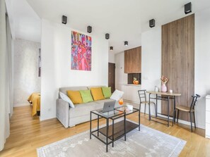 A modern living room with a sofa, coffee table, and a painting on the wall. - Warsaw Flat With Quiet Loggia (Warsaw)