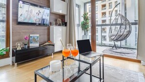 Ein modernes Wohnzimmer mit einem Glastisch, einem Laptop und zwei Gläser Orangensaft.