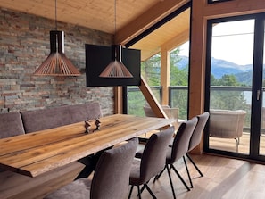 Ein moderner Essbereich mit Holztisch, gepolsterten Stühlen und Pendelleuchten.