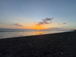 Ein Strand mit Sonnenuntergang über dem Meer.
