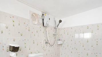 Uma casa de banho com sanita, chuveiro e secador de mãos.