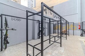 A metal bike rack with multiple hooks and a bicycle parked beside it. - Studio in downtown São Paulo. Metro República. Easy access to Brás and 25 de Março. (São Paulo)