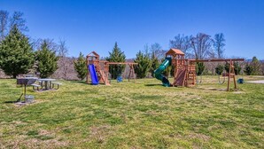 A playground with swings, slides, and picnic tables.