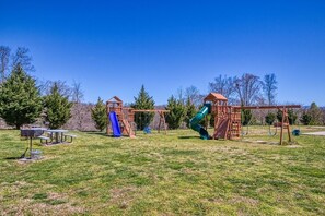 A playground with swings, slides, and picnic tables.