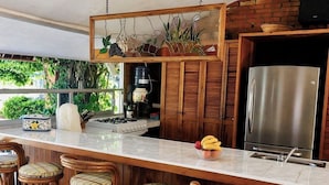Una cocina con una isla central, armarios de madera y un refrigerador de acero inoxidable.