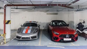 Eine Parkgarage mit zwei Autos, eines mit einem sichtbaren Logo und das andere mit einem erkennbaren Wappen.