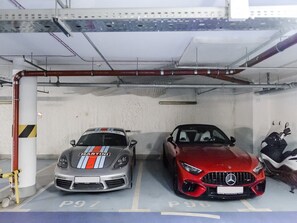 A parking garage with two cars, one with a visible logo and the other with a visible emblem. - Central Warsaw Home With Pool (Warsaw)