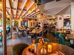 An indoor dining area with tables, chairs, and hanging lights. - Charming Chalet Near Efteling (Kaatsheuvel)