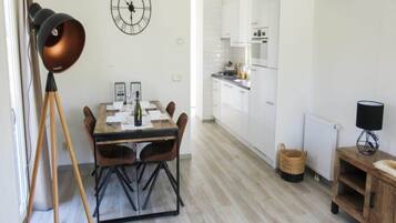 A modern kitchen with white cabinets and a dining area with a wooden table and chairs.