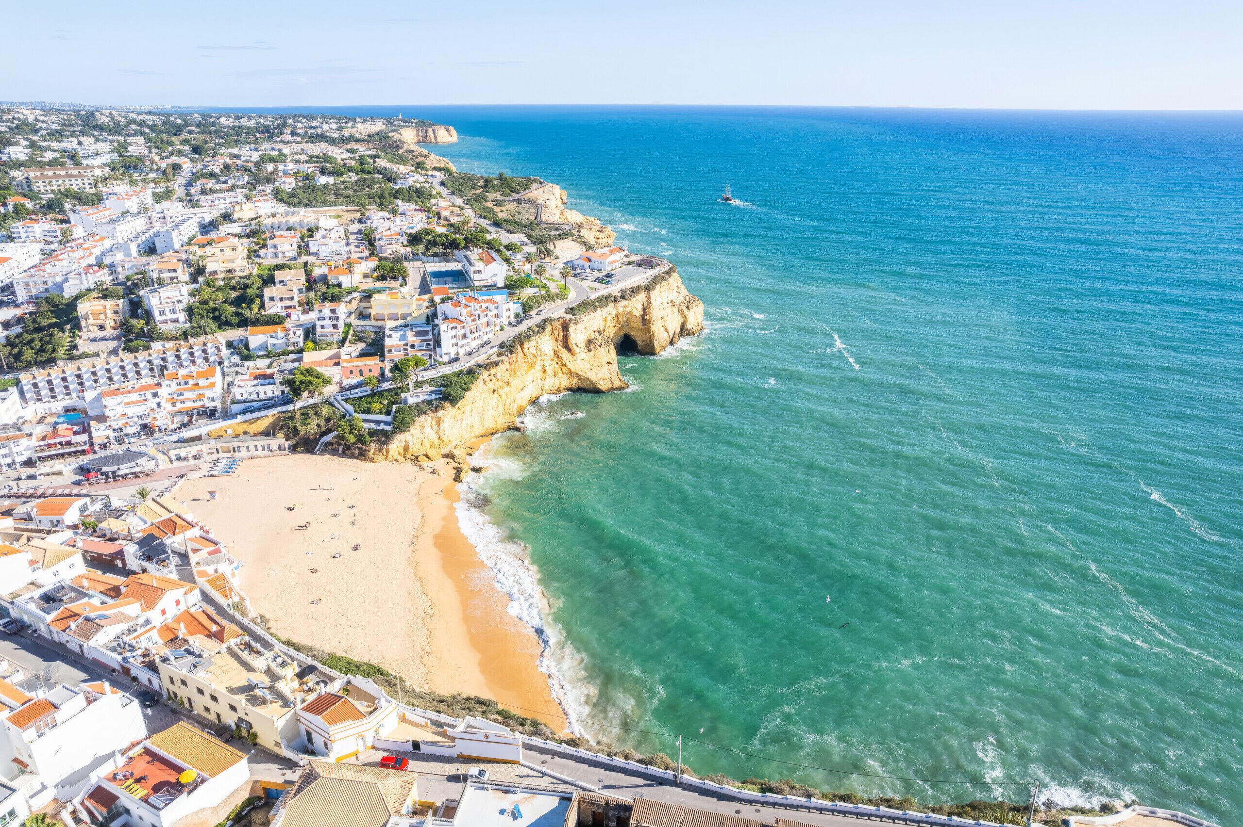 Une ville côtière avec une plage, des bâtiments et des falaises.