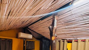 Una habitación con una cama, un poste de madera, un ventanal y una cortina.