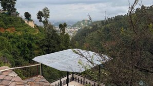 Tinaco en azotea con vista a paisaje urbano.