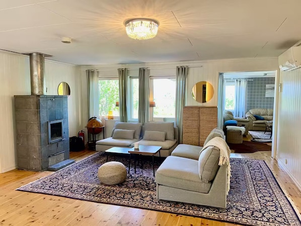 A living room with a fireplace, sofas, a coffee table, and a patterned rug.
