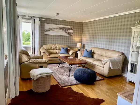 A living room with a sofa, a coffee table, a rug, and a lamp.