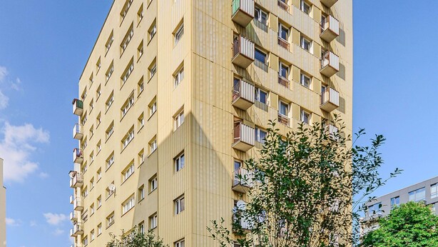 Um edifício residencial com vários andares, varandas e janelas.