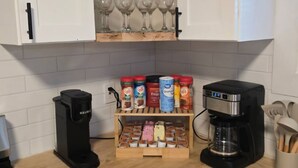 A kitchen with a coffee maker, a spice rack, and a cabinet with wine glasses. - Spacious 5-bedroom house in awesome Detroit with AC (Detroit)