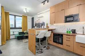 A modern kitchen with wooden cabinets, a built-in microwave, and a stainless steel oven. - Lush Home Near Varso Tower (Warsaw)