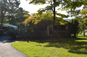 Ein Haus mit Veranda, Rasen und Auffahrt.