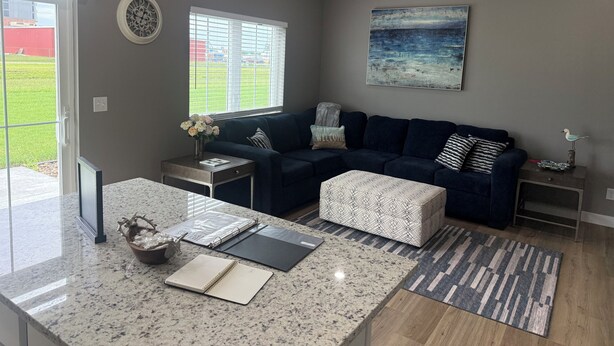 Ein Wohnzimmer mit einem dunkelblauen Sofa, einem Couchtisch, einem Teppich und einem Bild an der Wand.