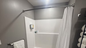 Ein Badezimmer mit Dusche, Toilette und Handtuchhalter.
