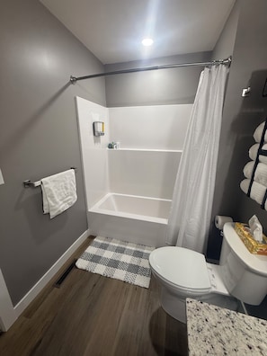 Ein Badezimmer mit Dusche, Toilette und Handtuchhalter.
