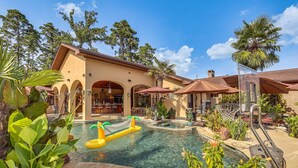 Un espace piscine doté d’un jacuzzi, de parasols et d’un bar/salon.
