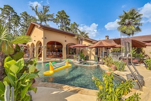 Un área de piscina con jacuzzi, sombrillas y un bar-lounge.