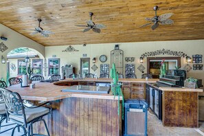 Una cocina amplia con una isla curva, techo de madera y ventiladores de techo.