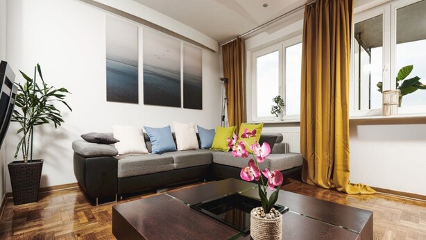 A modern living room with a sectional sofa, a coffee table, and a large window with curtains. - Warsaw Home Near Center (Warsaw)