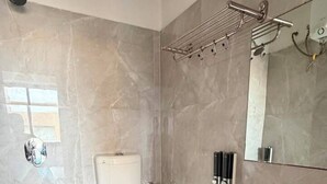 A bathroom with a toilet, sink, shower, and towel rack. - HOTEL MARUTI R FAMILY PRIME  (Ahmedabad)