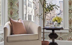 A room with a sofa, a vase with flowers, a pitcher, and a table. - Uptown Charlotte Luxury 4 bedroom Townhouse walkable to everything (Charlotte)