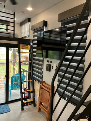 Ein modernes Interieur mit einer Treppe, einem großen Fenster und Blick ins Freie.