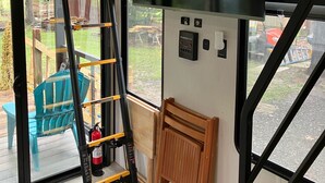 A room with a black and yellow ladder, a wooden bench, a window with blinds, and a control panel on the wall. - Beautiful 3-bedroom recreational vehicle with water view in Bronson (Bronson)
