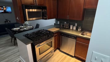 Una cocina moderna con armarios de madera, electrodomésticos de acero inoxidable y una isla central.